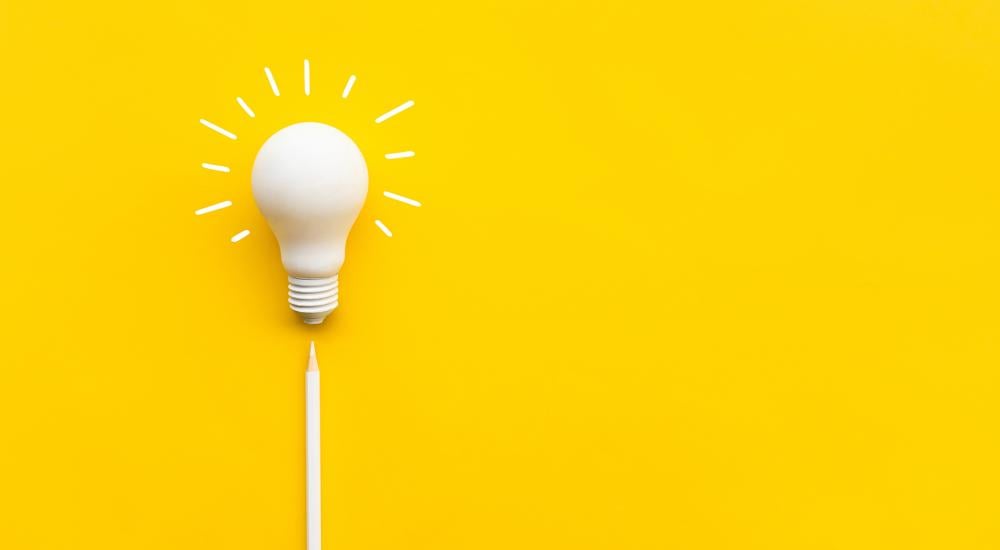 A white lightbulb on a yellow background