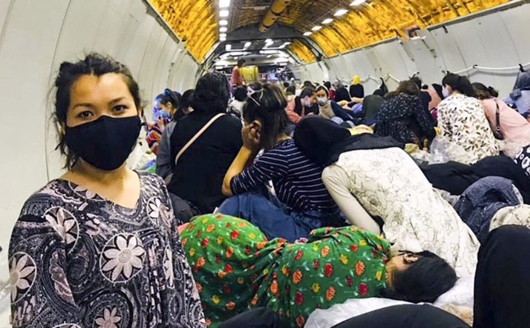 An ASU student sits on a crowded military plane
