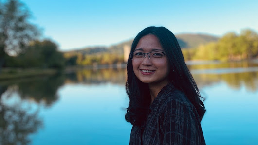 Photo of a student in front of a lake