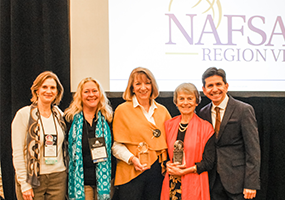 A photograph of Marian Beane and Judy Case receiving an award from the NAFSA Regional team.