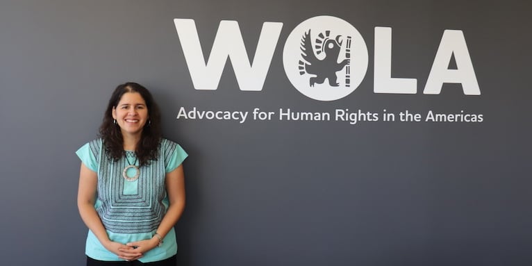Carolina Jiménez Sandoval standing in front of the WOLA sign