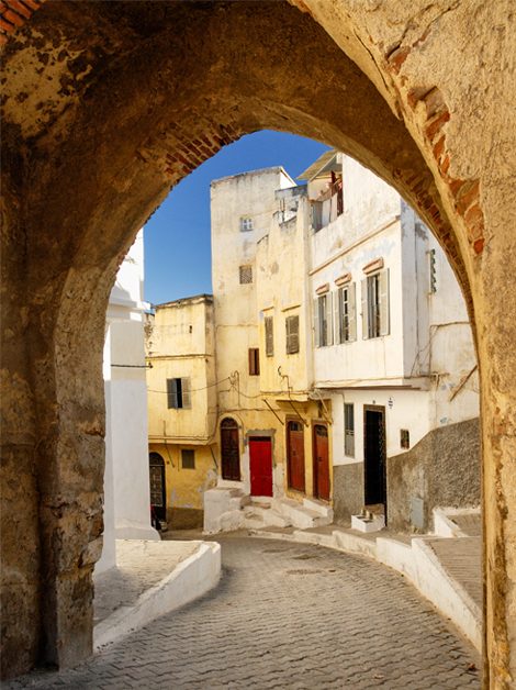 An archway in Tangier stretches over a road, revealing a street