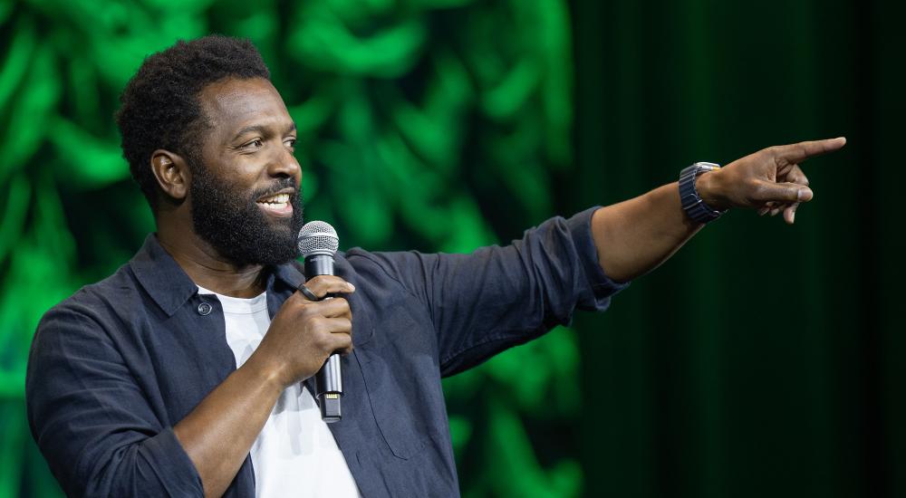 Baratunde Thurston points on stage at the NAFSA conference.