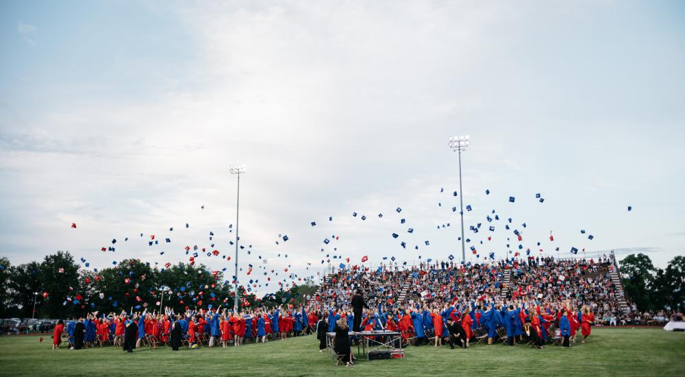 students throwing caps in the air at a graduation ceremony