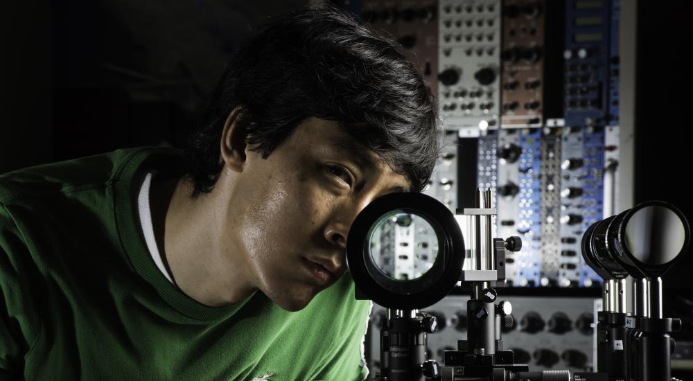 student looking through a microscope