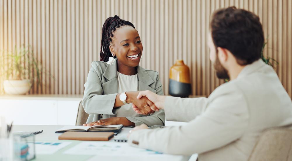 smiling businesswoman shaking hands with man