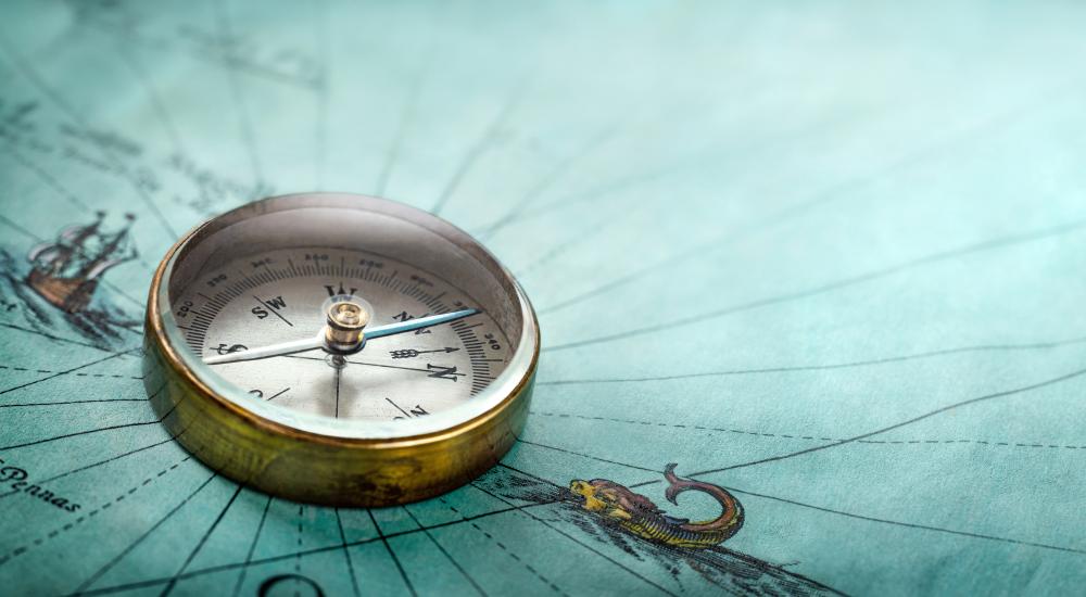 brass compass on old map