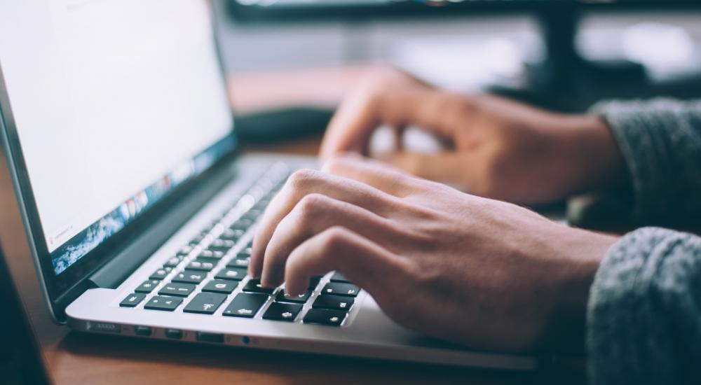 hands typing on a laptop