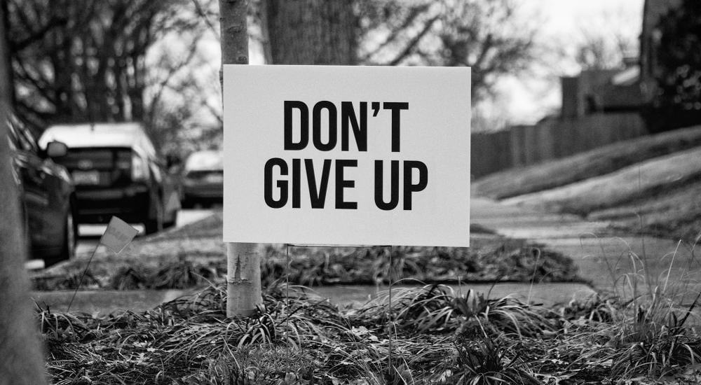 Yard sign that says, Don't Give Up