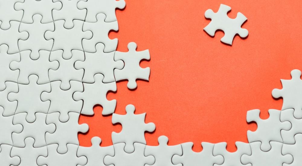 White puzzle pieces on an orange background