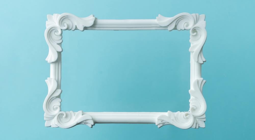 White ornate picture frame on a blue background