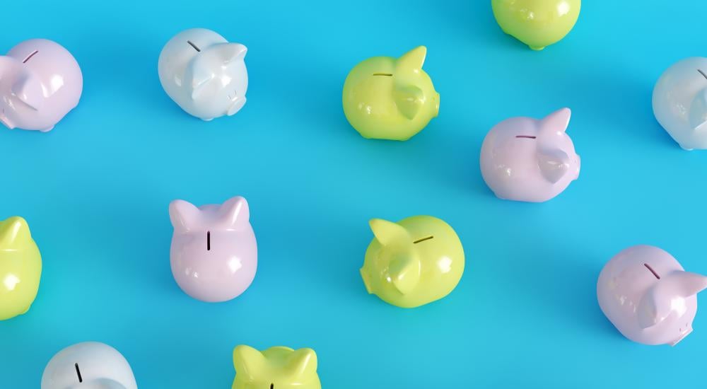 Different colored piggy banks on a blue background