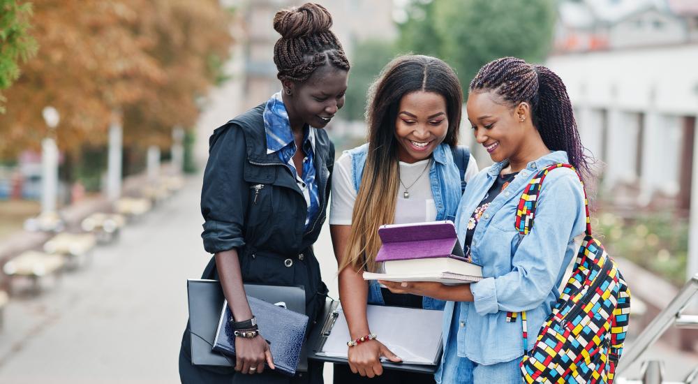Three African students talk together