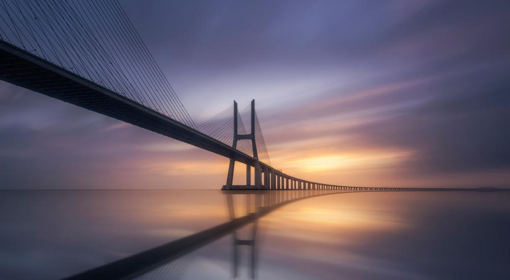 Photo of a bridge against a purple sky