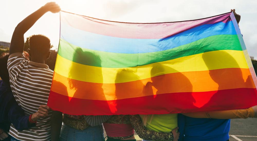 Photo of a group of students holding a pride flag.