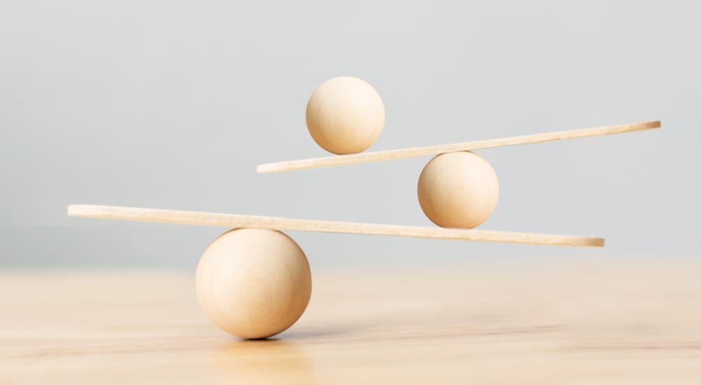 Three wooden balls balancing on two planks 