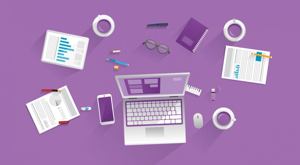 birds-eye view of desk with computer, papers, coffee cups