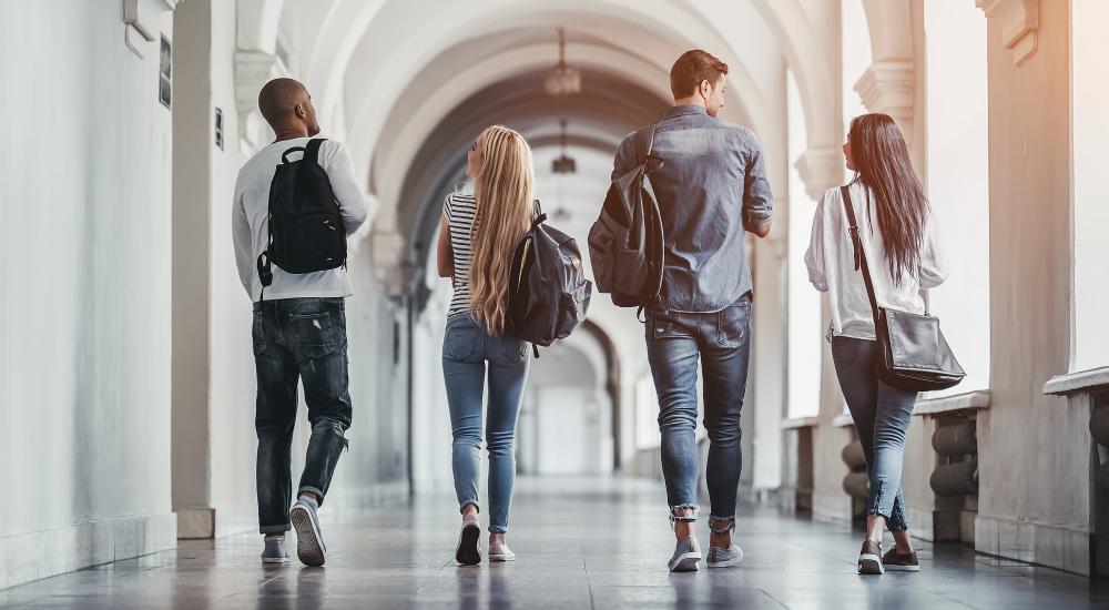 Four students walking down a hallway