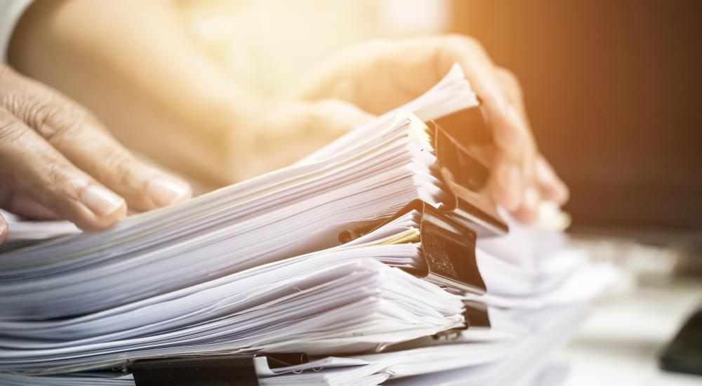 Person going through a stack of paperwork