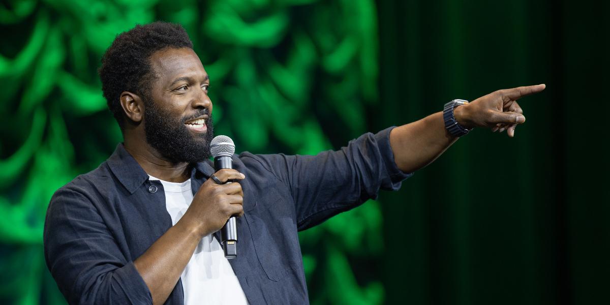 Baratunde Thurston points on stage at the NAFSA conference.