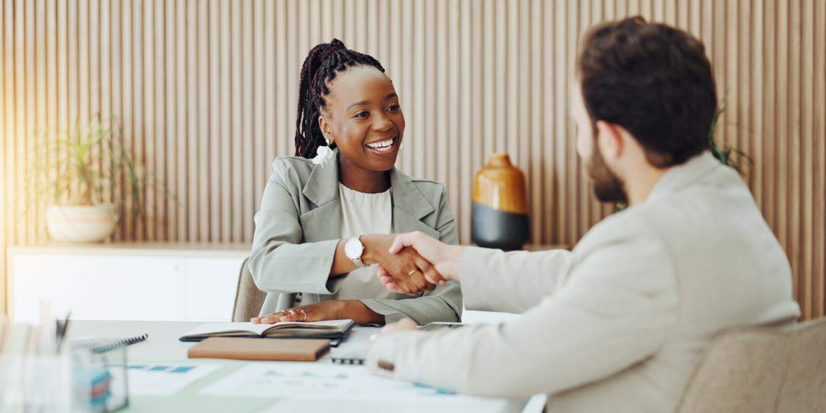 smiling businesswoman shaking hands with man