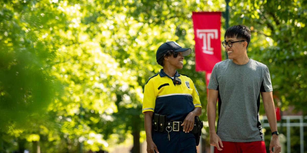 International student and police officer walking on campus