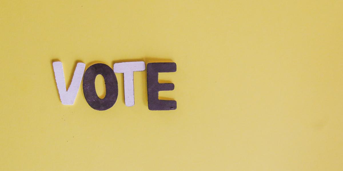"VOTE" cutout letters on yellow background
