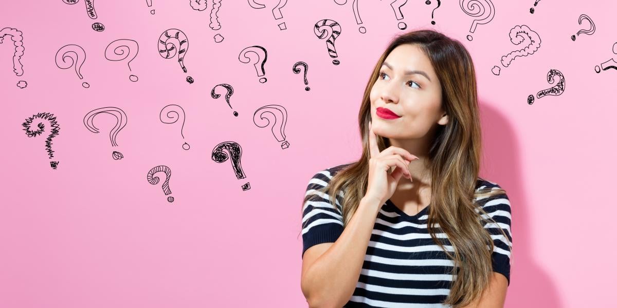 question marks on a pink background with a girl in the foreground