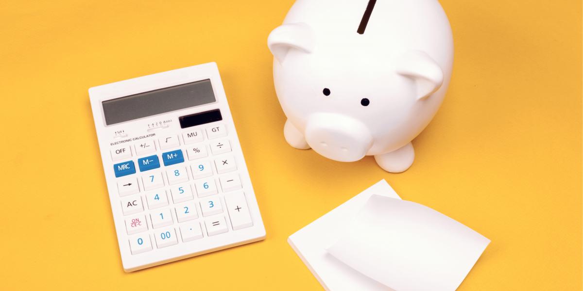 piggy bank and calculator against yellow background