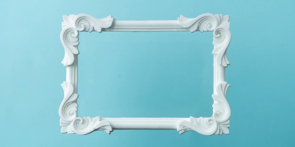 White ornate picture frame on a blue background