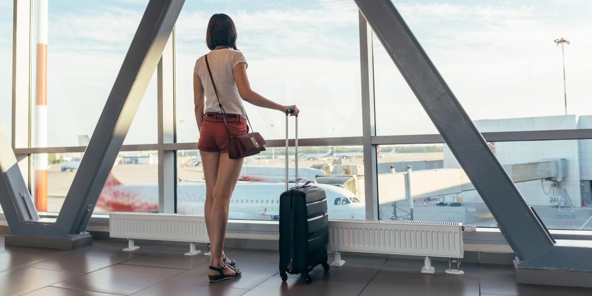 Student waiting at the airport with luggage