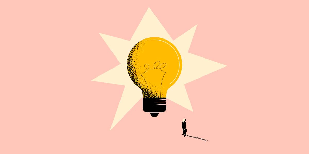 small figure stands looking up at big light bulb