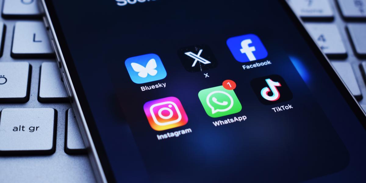 image of a cell phone with social media icons on the screen