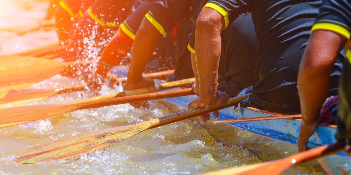 photo of people paddling a boat together