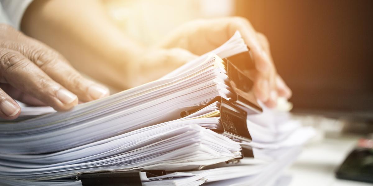 Person going through a stack of paperwork
