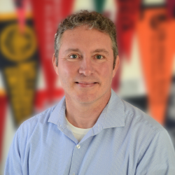 Headshot of Damien Marshall. Damien wears a light blue collared shirt