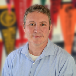 Headshot of Damien Marshall. Damien wears a light blue collared shirt 