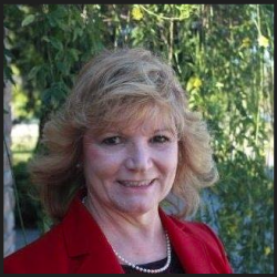 Mary-Ellen sit outside, wearing a red blazer