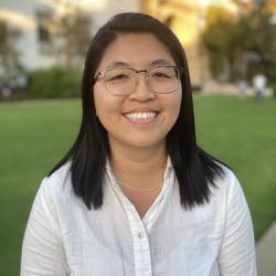 Woman smiling with glasses and medium length black hair
