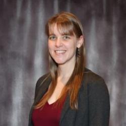Joanne smiles wearing a red shirt and blazer
