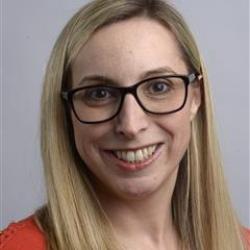 Morgan smiles in a red shirt