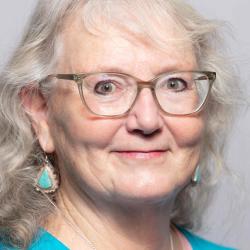 Elizabeth smiles in a bright blue shirt