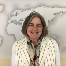 woman smiling at camera in front of world map