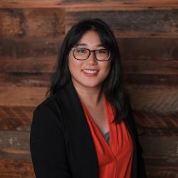 woman smiling at camera with wooden background