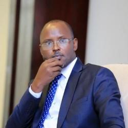Photo of Prof. KAYIHURA Muganga Didas sitting in a chair. 