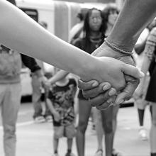 black and white photo of people holding hands at a protest.