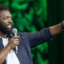 Baratunde Thurston points on stage at the NAFSA conference.