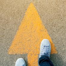 arrow on a road with feet