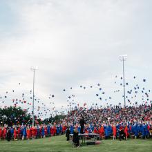 students throwing caps in the air at a graduation ceremony