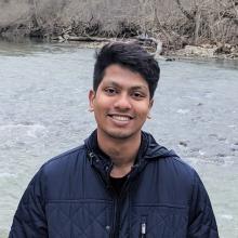 A student standing in front of a river